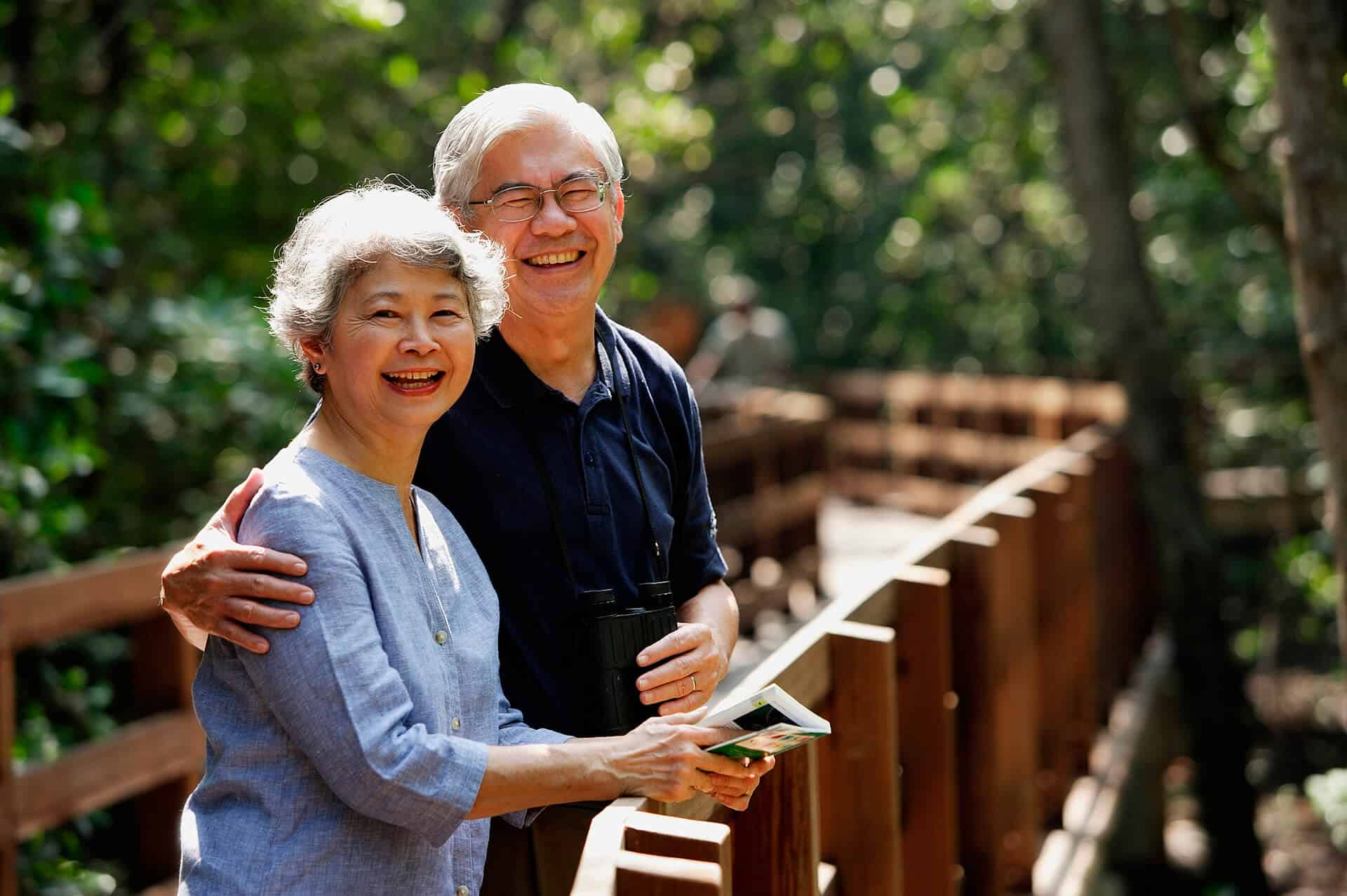 A couple of elderly in the park smiling