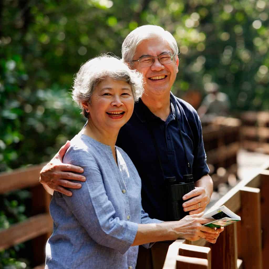 A couple of elderly in the park smiling 2