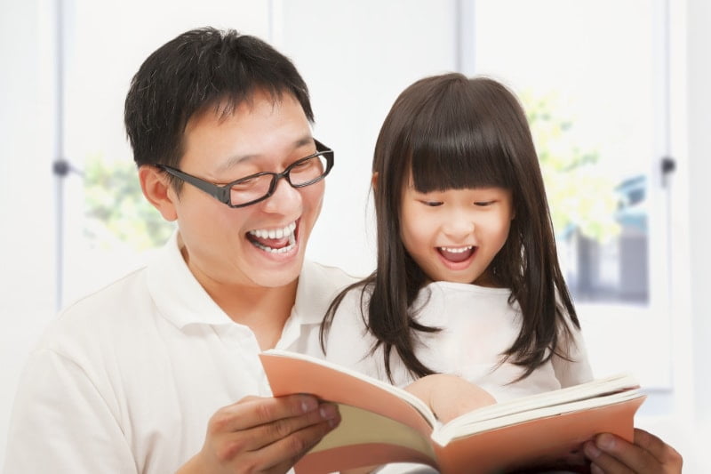 Kids Dentist Singapore - a father teaching her daughter about oral care and preventing tooth decay